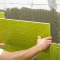 man-installing-green-wall-tile